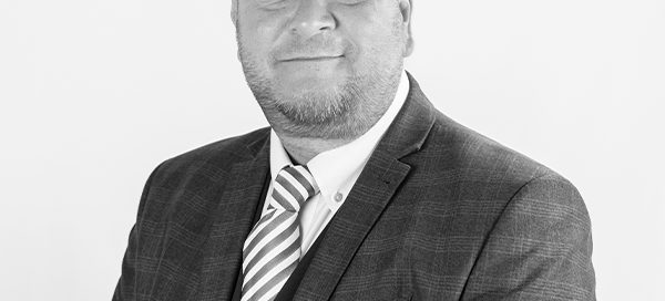 grey filtered headshot of Steve Anderson in suit and tie